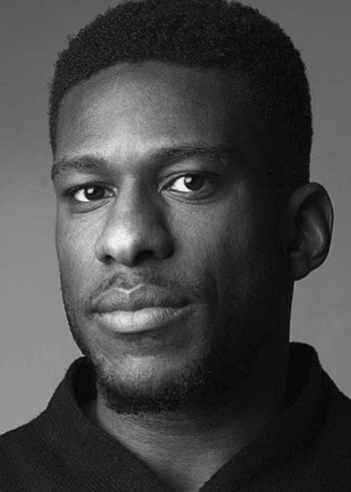 Black and white portrait of a man with a short haircut, looking at the camera.