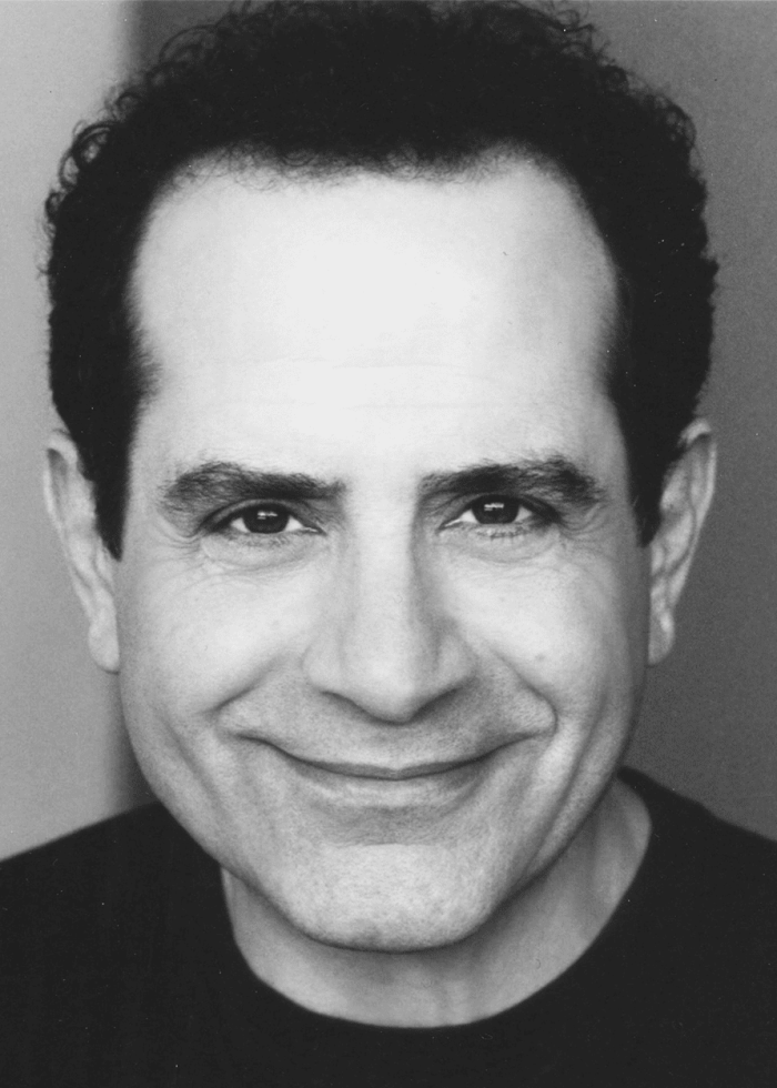 Tony Shalhoub smiling, close-up portrait.