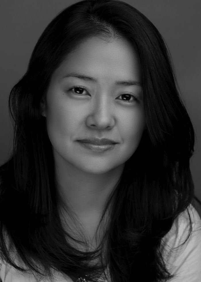 Headshot of Shannon Tyo, a woman with long dark hair, smiling slightly.