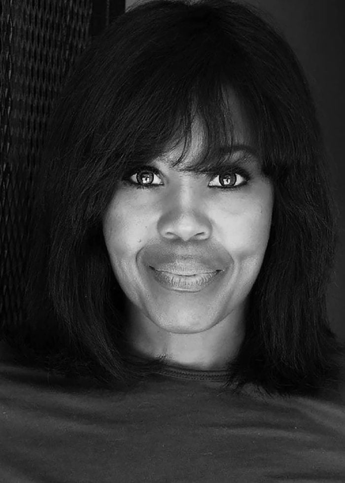 Sharon Catherine Brown smiles in a black and white portrait.