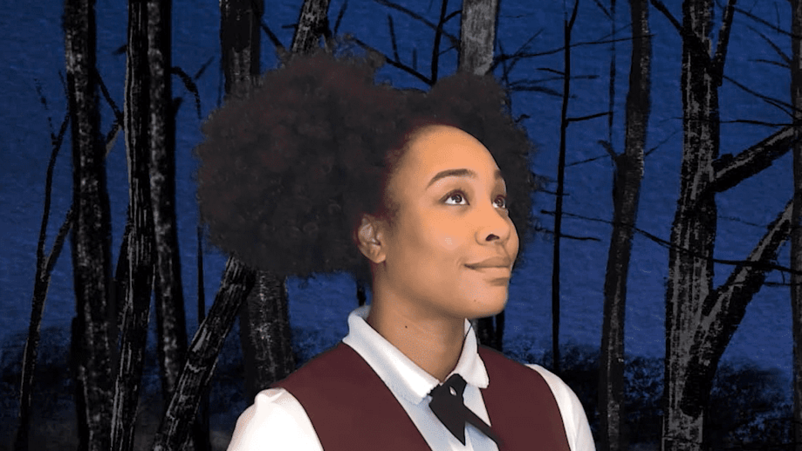 Young woman with afro looking up in a dark forest, She Persisted musical.