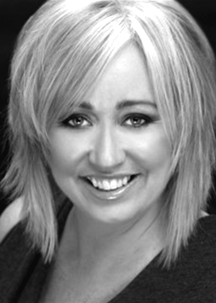 Shea Sullivan smiling with blonde, layered hair