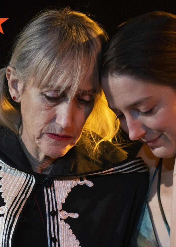 Two women embrace, one in a black coat, from Off-Broadway show "Shhhh.