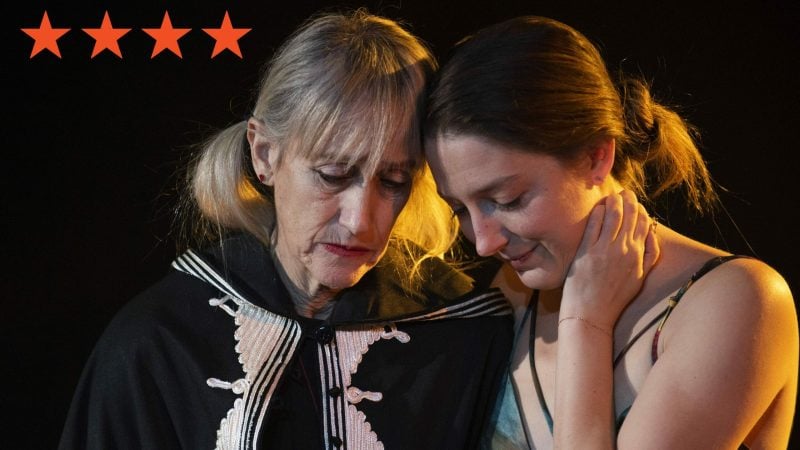 Two women embrace, one in a black coat, from Off-Broadway show "Shhhh.