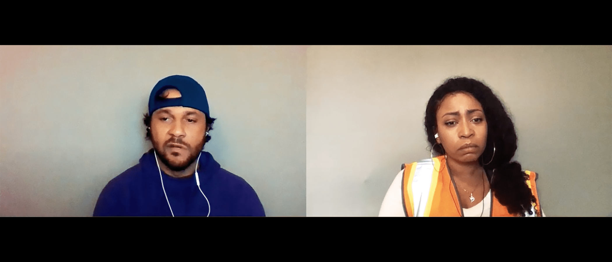 Two people in a video conference, one wearing a blue sweatshirt and baseball cap, the other wearing an orange safety vest.