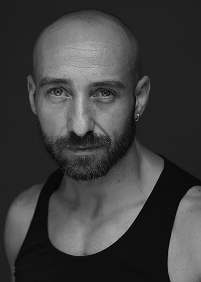 Skizzo Arnedillo portrait, bald man with beard and earring, wearing a black tank top.