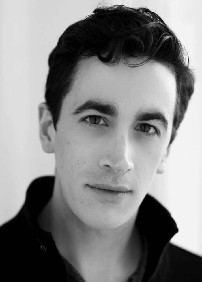 Headshot of a young man with dark hair and a serious expression.