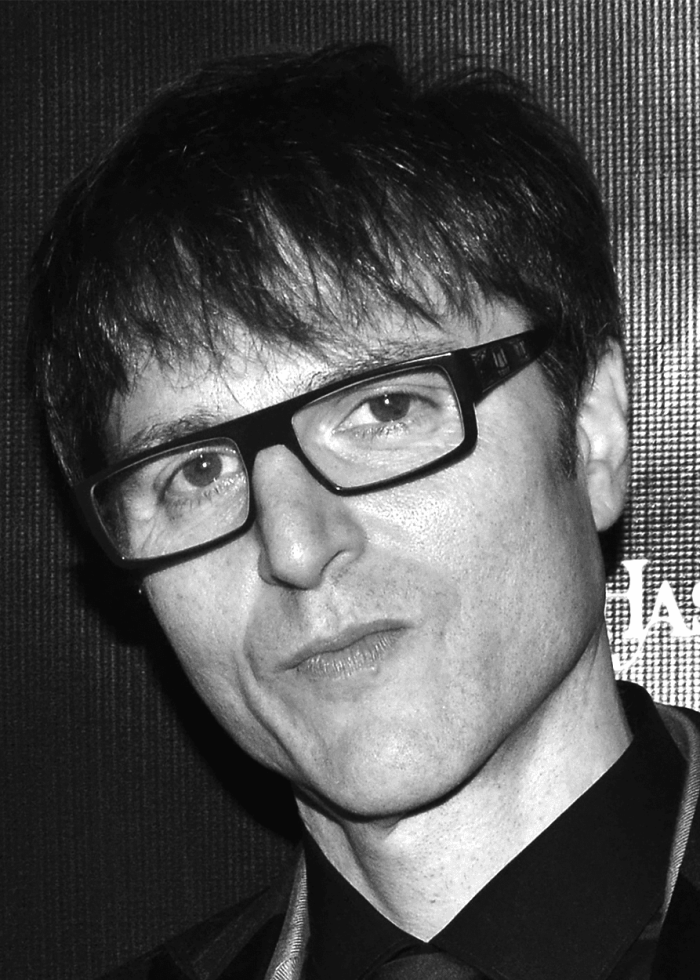 Stephen Trask, composer, wearing glasses, looking at the camera