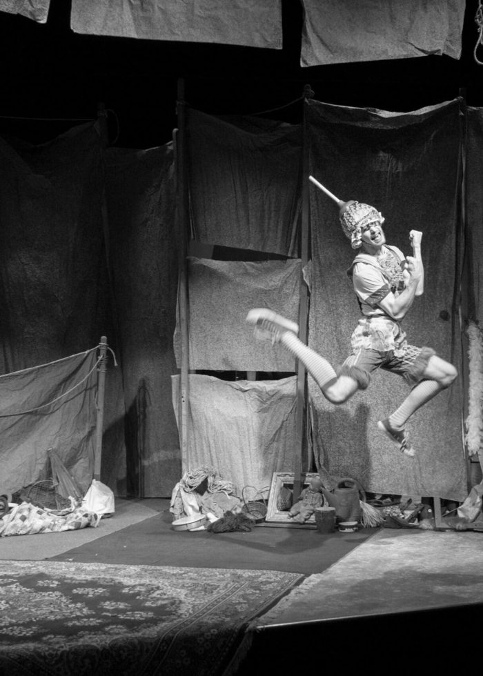 Actor in costume leaps on stage, part of a children's play. Spare Times for Children.