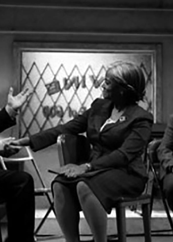 Scene from John Patrick Shanley's "Doubt" trilogy: actors in a black and white play, with a woman and man in the foreground.