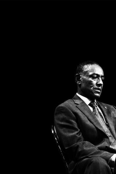 Black and white photo of two men in suits, one appearing pensive, the other gesturing.