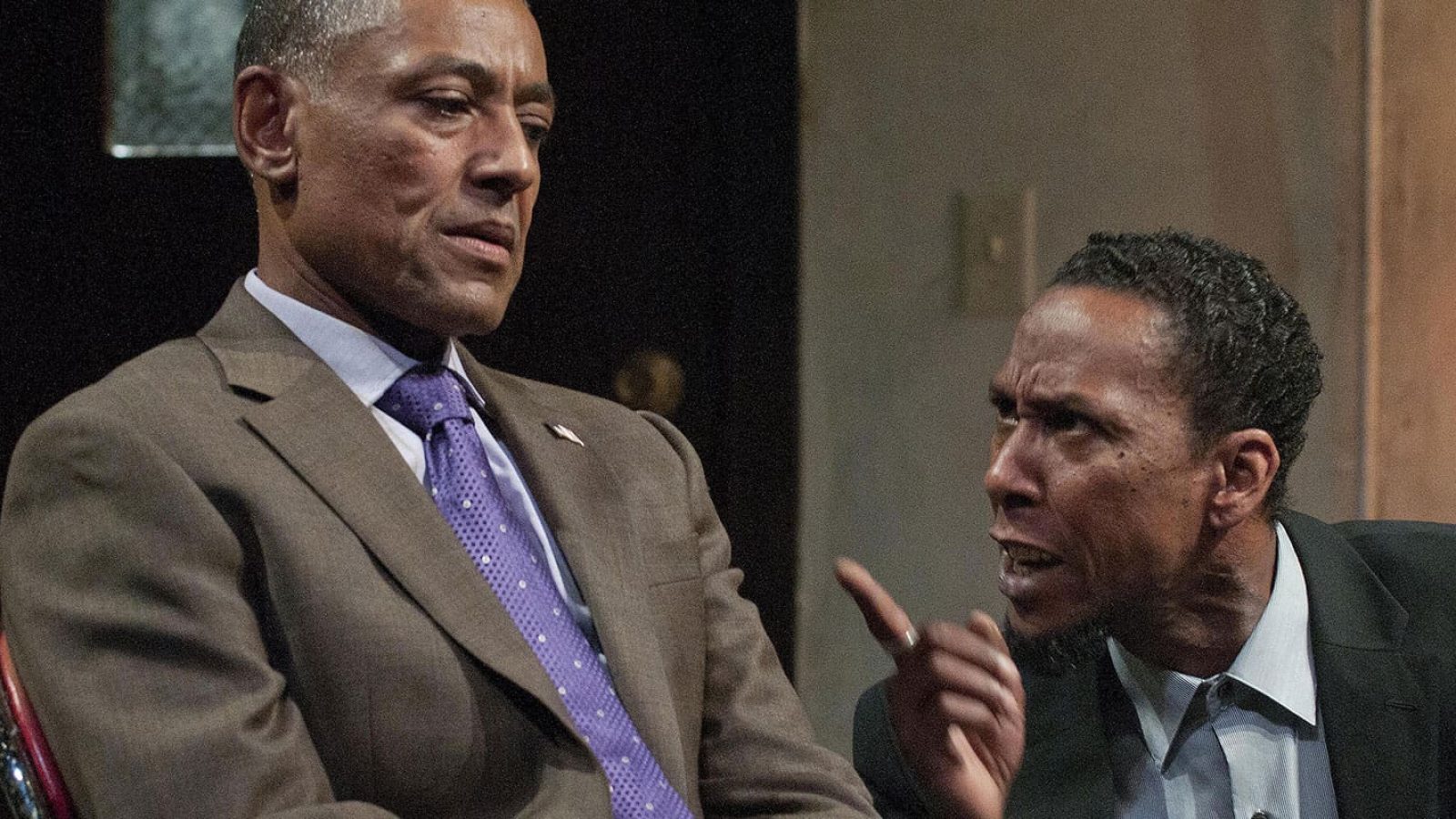 Two men in suits having a serious conversation.