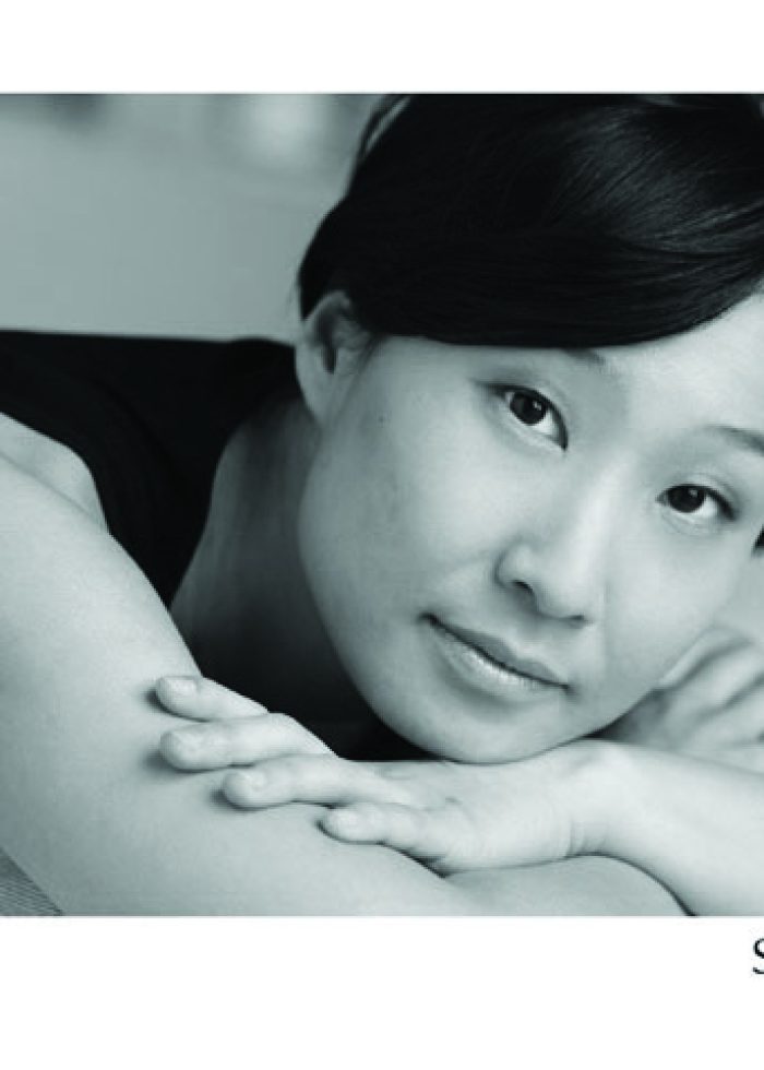 Susan Hyon portrait, woman resting her head on her arms, black and white photo.