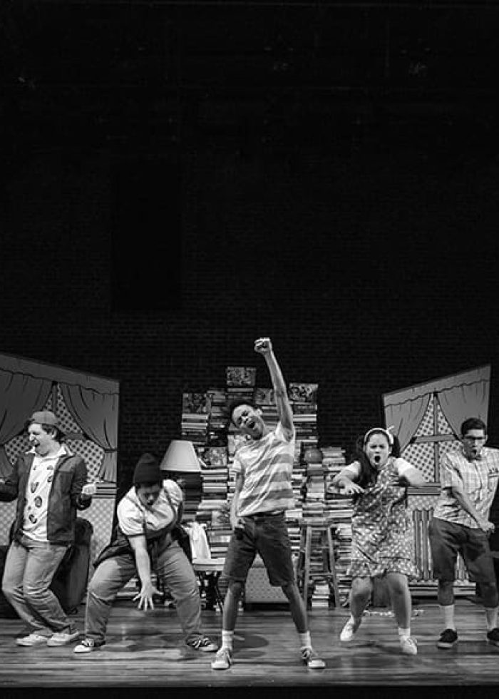 Cast of "The Big One-Oh!" musical on stage, performing a dance routine