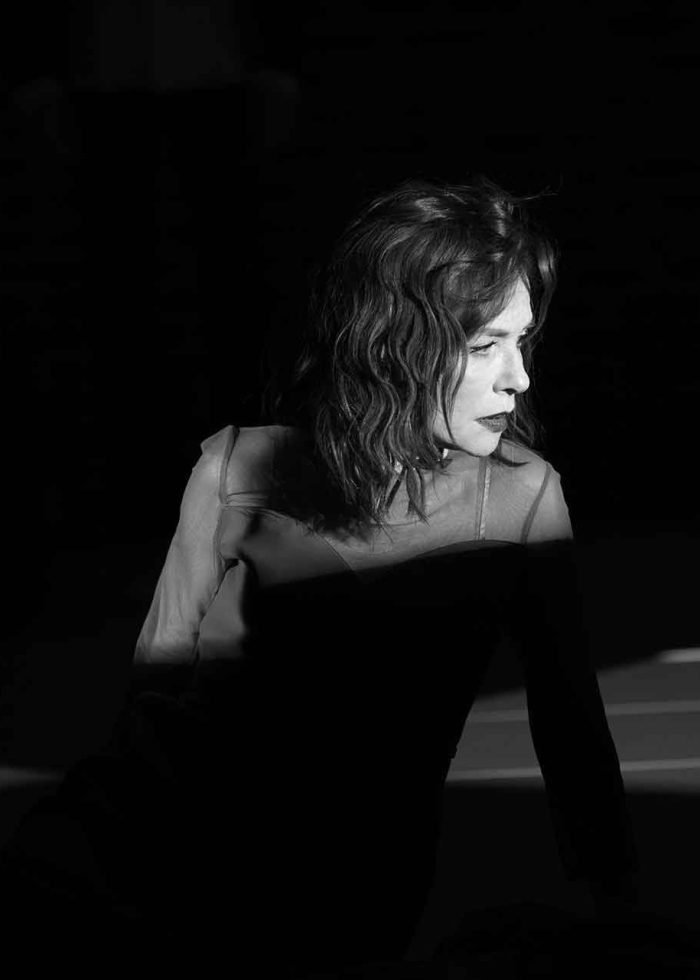 Actress in dramatic lighting, performing in a theater production from 2019.