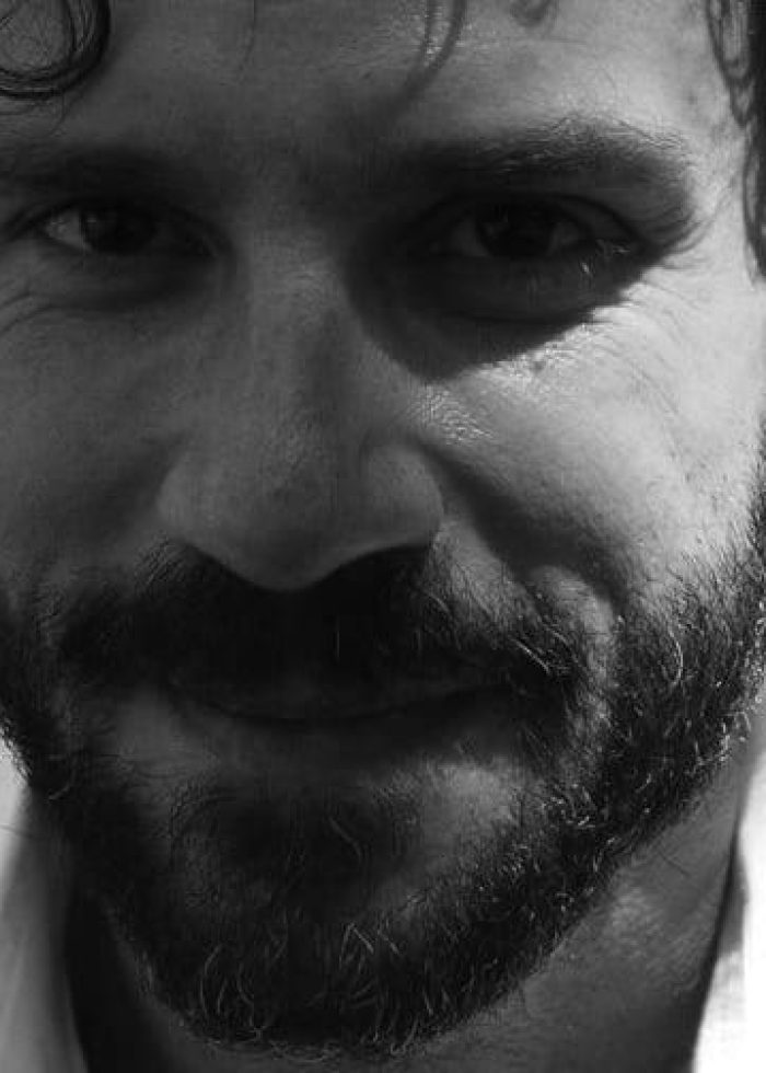 Director Dobrish, smiling with a beard, looking directly at the camera