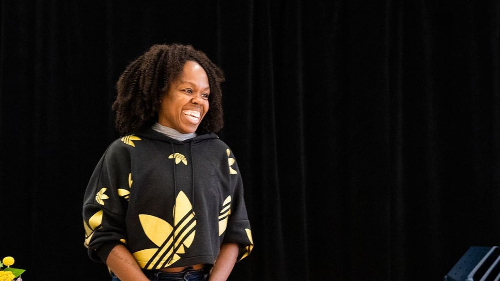 Happy Black woman wearing an Adidas hoodie