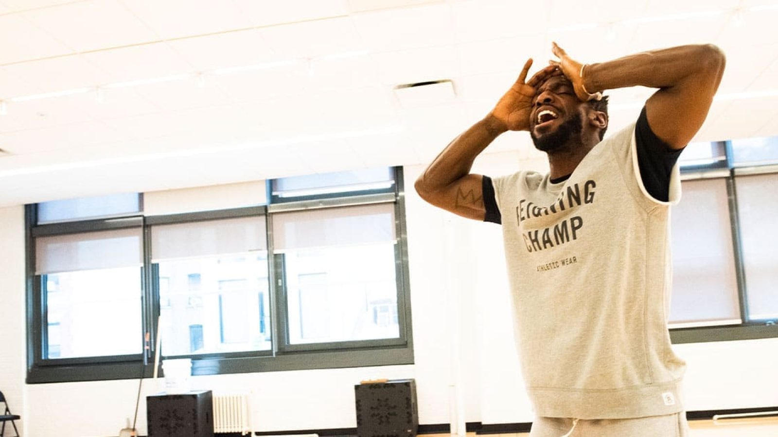 Man in "Reigning Champ" sweatshirt, hands on head, expressing distress.
