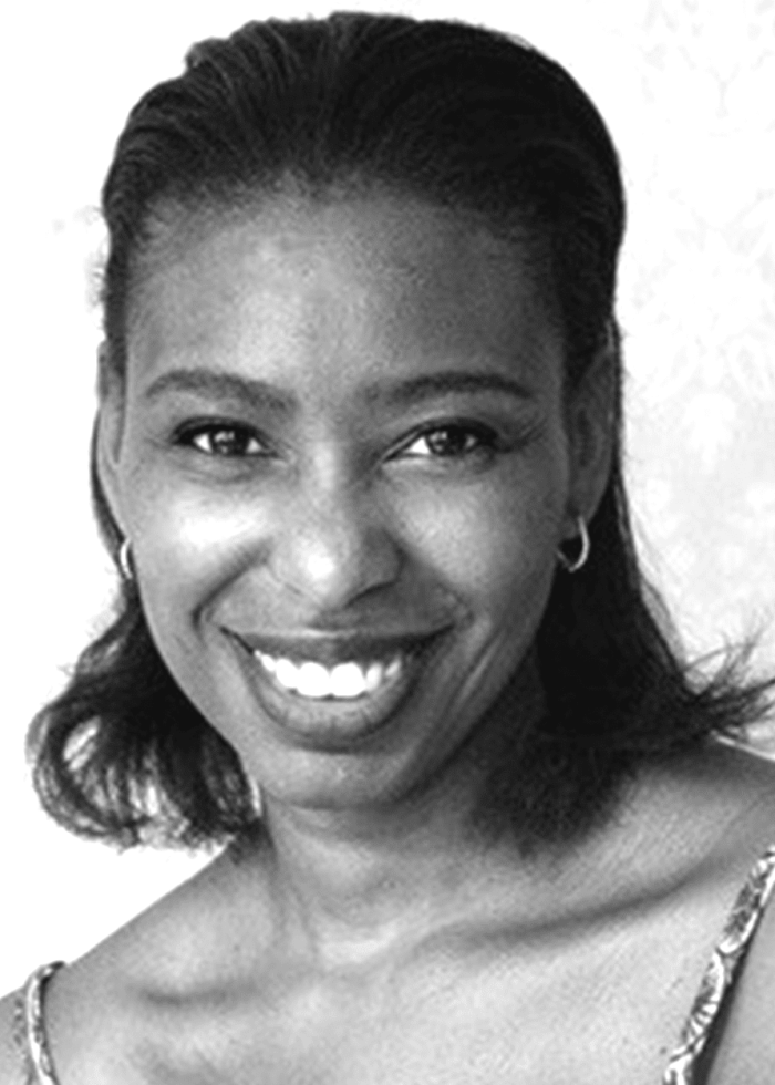 Portrait of Tamilla Woodard smiling, looking directly at the camera.