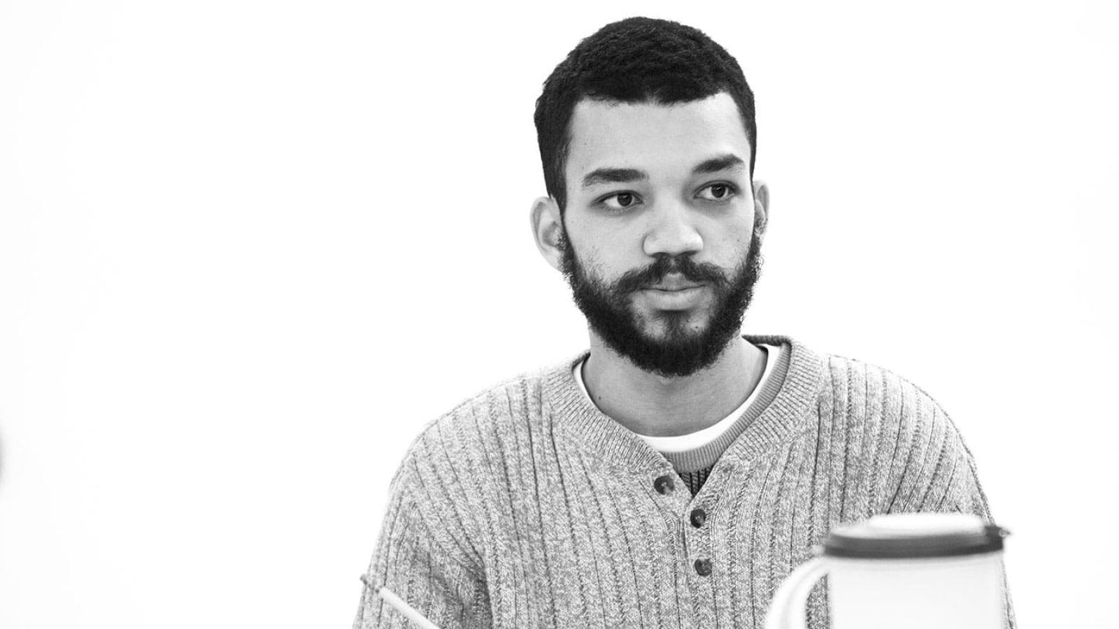 Thoughtful young man with beard, listening attentively.