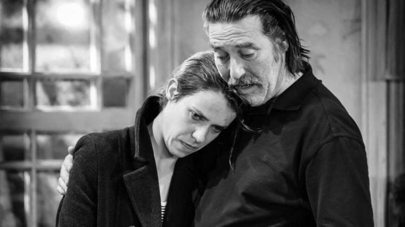 Two actors embrace in a scene from The Night Alive, a black and white theater production.