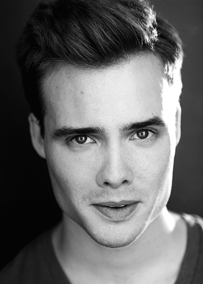 Mickey Theis looking directly at the camera, black and white headshot.
