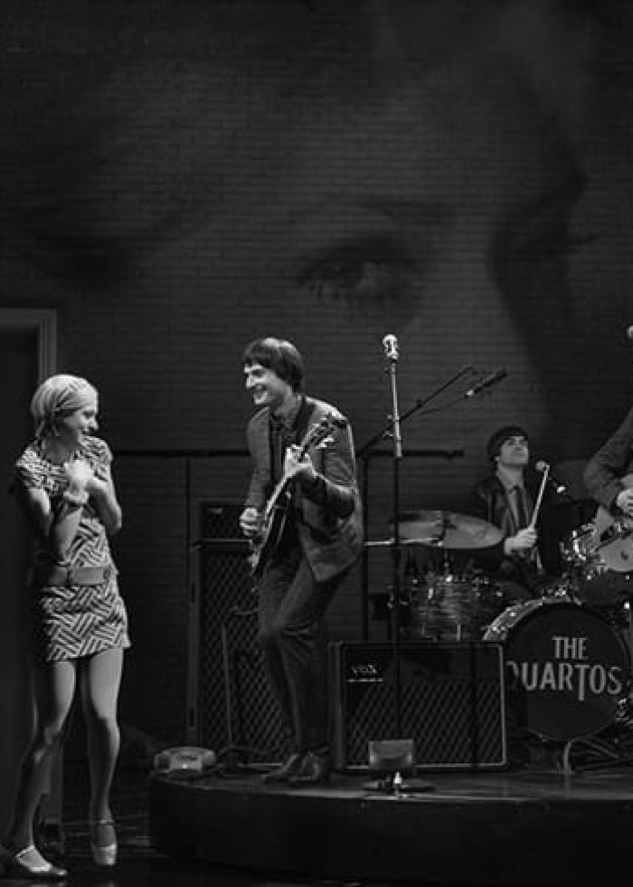 Band "The Quartos" performing on stage with a woman in a mod dress, as seen in "These Paper Bullets!