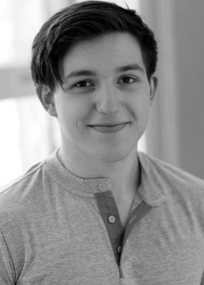 Thomas Prast smiling in a gray Henley shirt, looking at the camera.