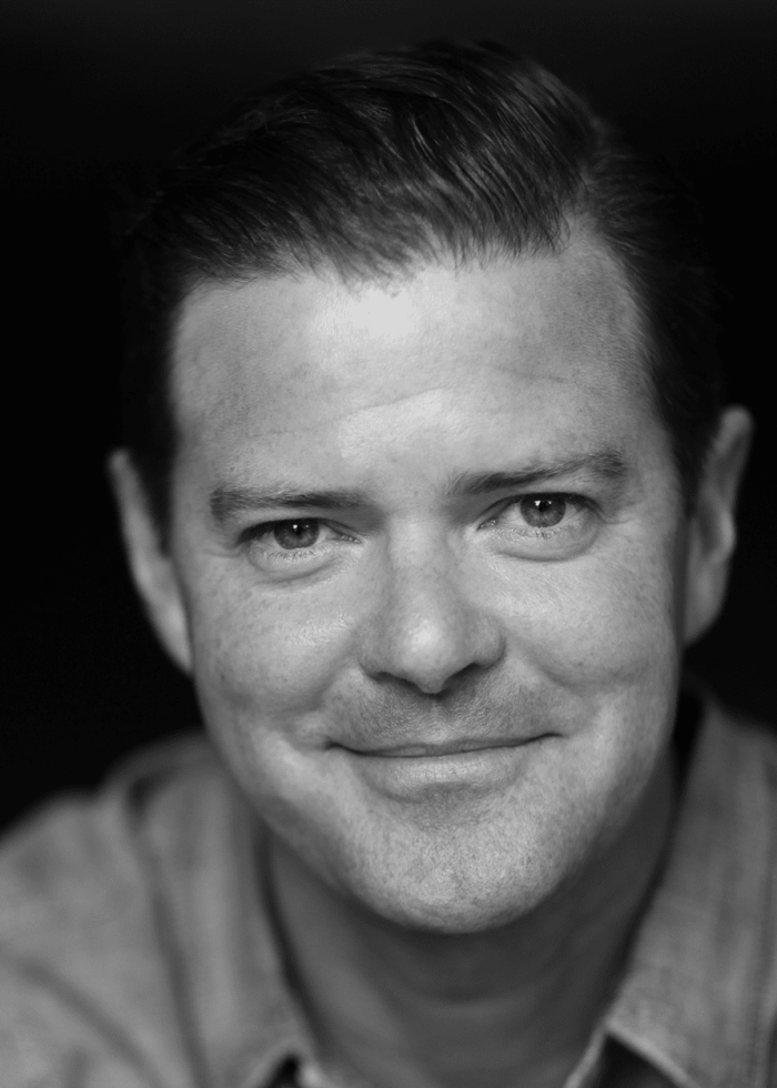 Clarke Thorell smiles in a black and white headshot
