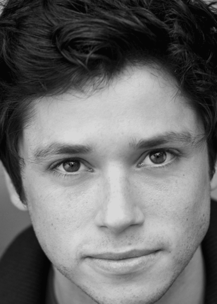 Close-up headshot of actor Raviv Ullman, looking directly at the camera.