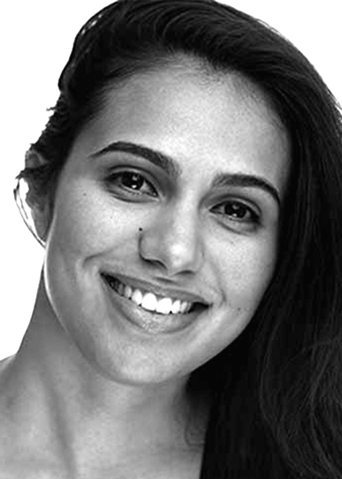 Analisa Velez smiling with dark hair, looking at the camera.