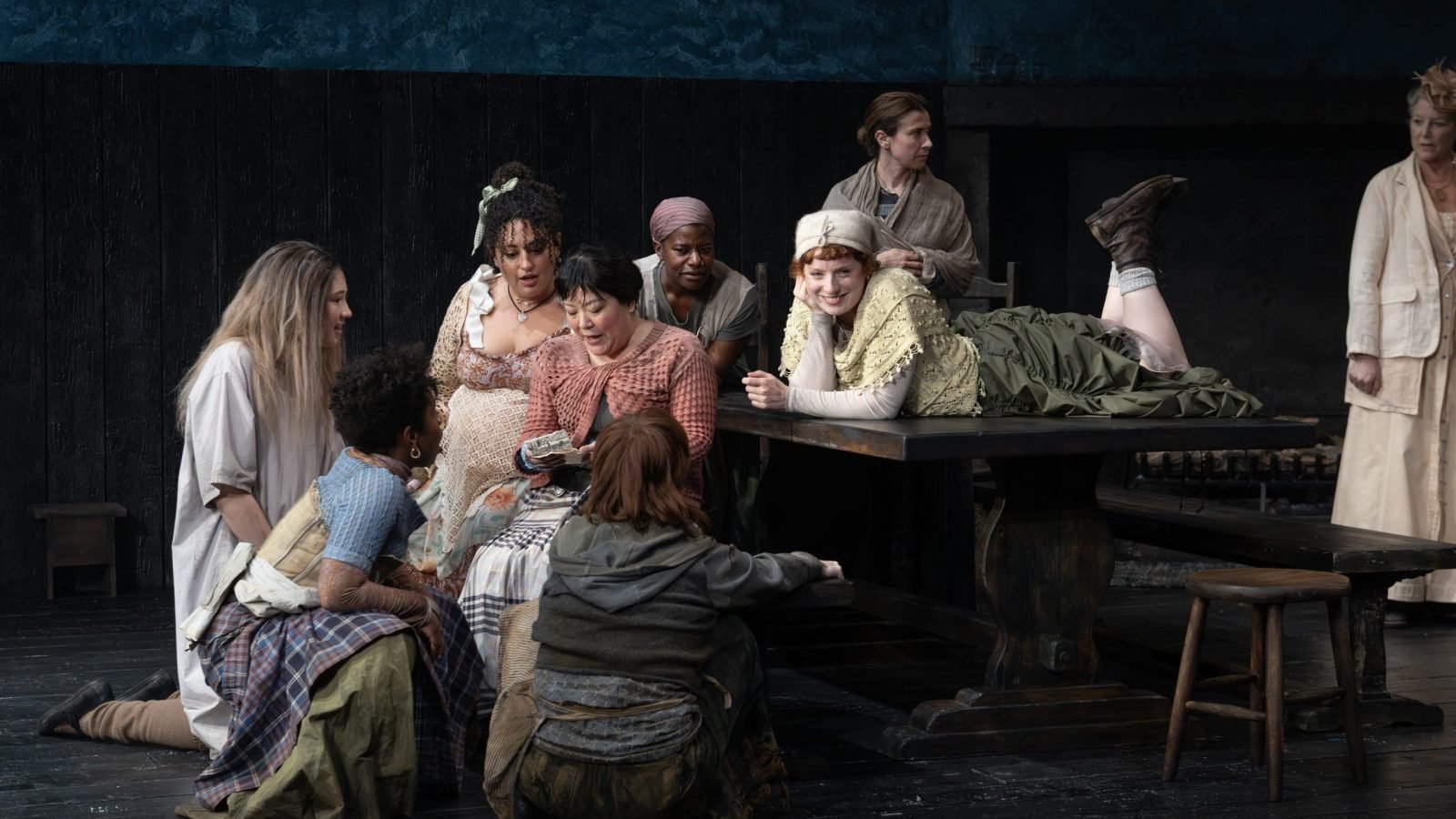 A group of women gathered around a table, sharing a moment.