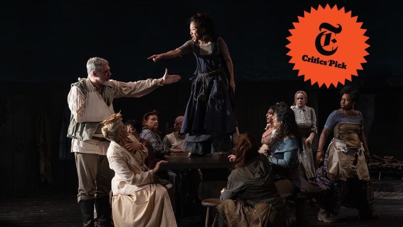 Scene from "The Welkin" play: Woman on table points, surrounded by actors. Critics' Pick logo visible.