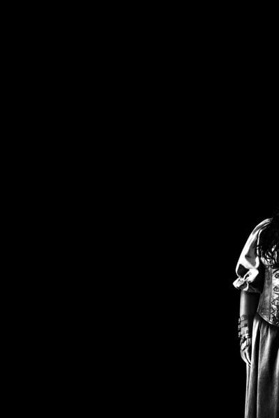 Black and white portrait of a woman wearing a horned helmet and corset.