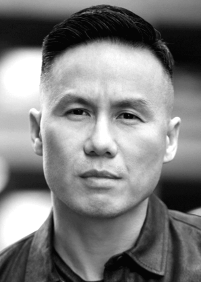 BD Wong looking directly at the camera, wearing a dark shirt. Portrait in black and white.