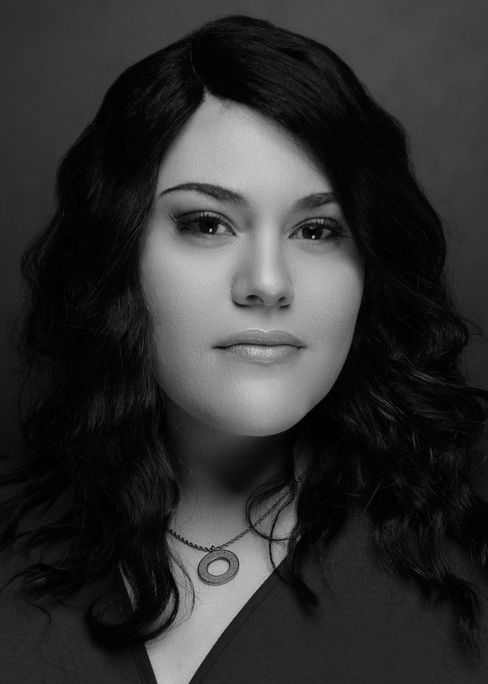 Black and white portrait of a woman with dark wavy hair and a necklace, from Else Went.