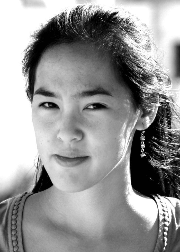 Portrait of a woman with long dark hair, wearing an earring and looking directly at the camera.
