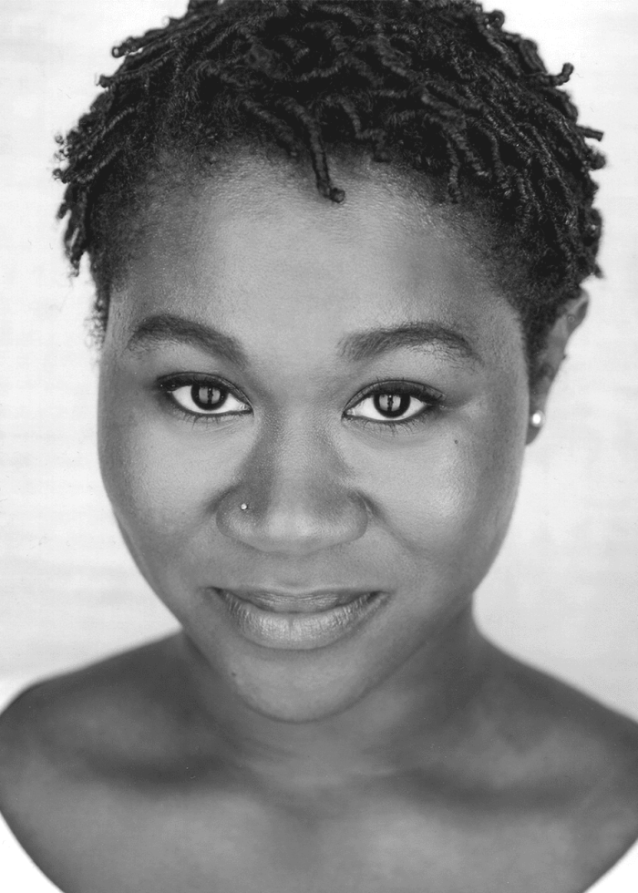 Headshot of Zenzi Williams with short locs and a small nose ring, smiling gently.