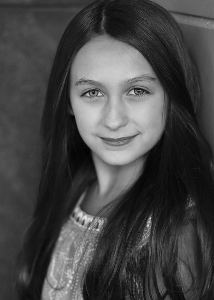 Zoe Glick portrait, young girl with long hair smiling at the camera.