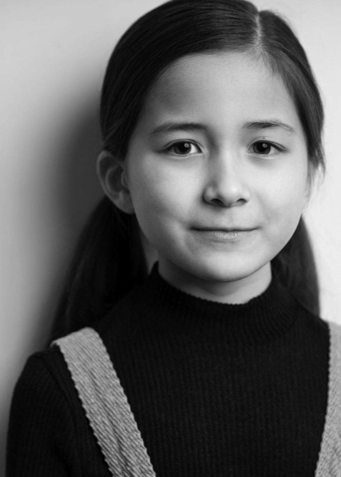 Young girl with pigtails, wearing a black turtleneck. Portrait for Charlie Tassone blog.