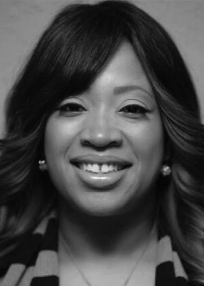 Deah Harriott smiling in a black and white headshot