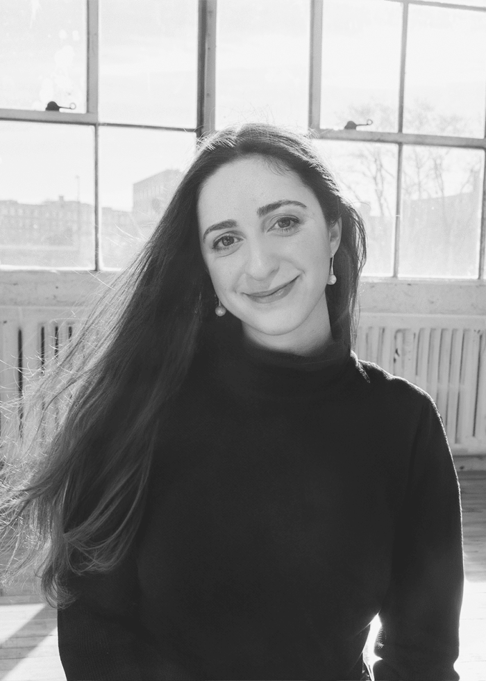 Eliya Smith smiling with long hair in front of large windows