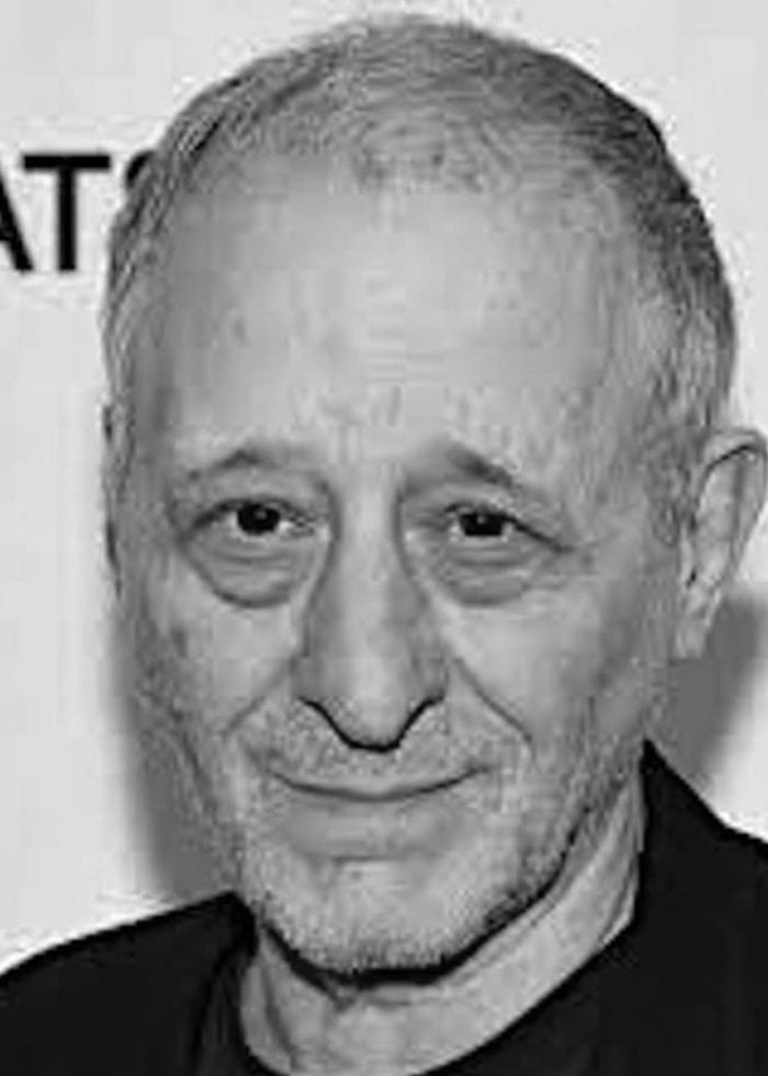 Joe Grifasi, actor and playwright, smiling in a black and white portrait.