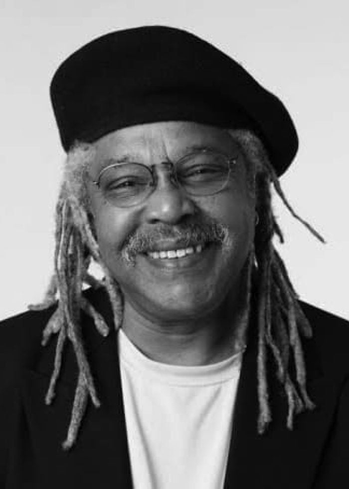 Juan de Marcos smiling, wearing glasses and a beret.