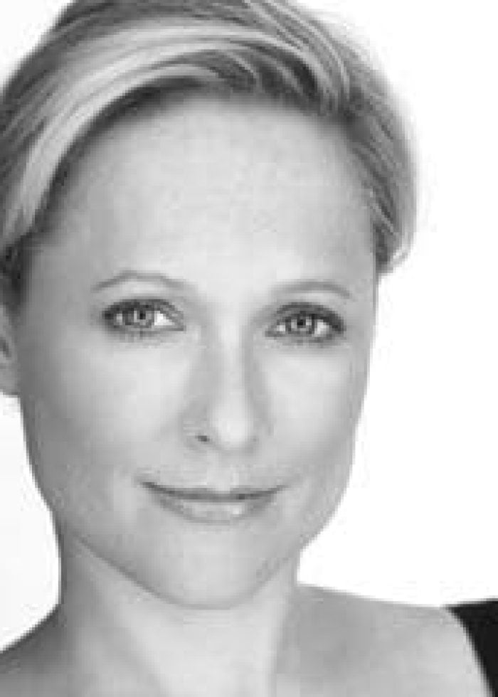 Kate Blumberg portrait, smiling with short blonde hair