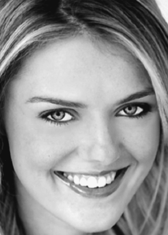 Close-up portrait of Katie Brady smiling, featuring bright teeth and blonde hair.