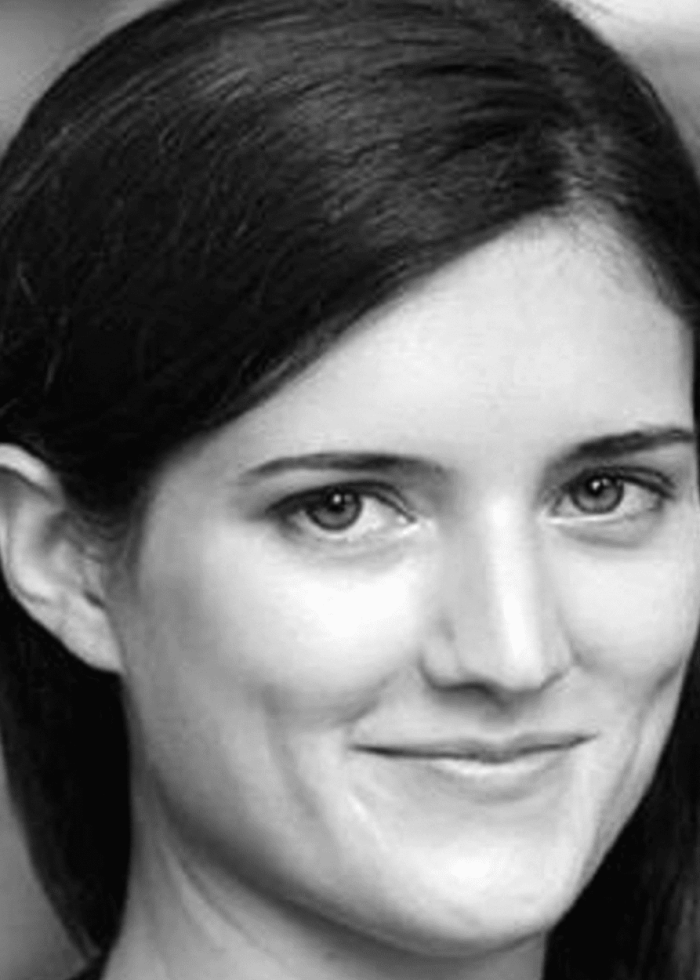 Portrait of a woman with dark hair, smiling gently.