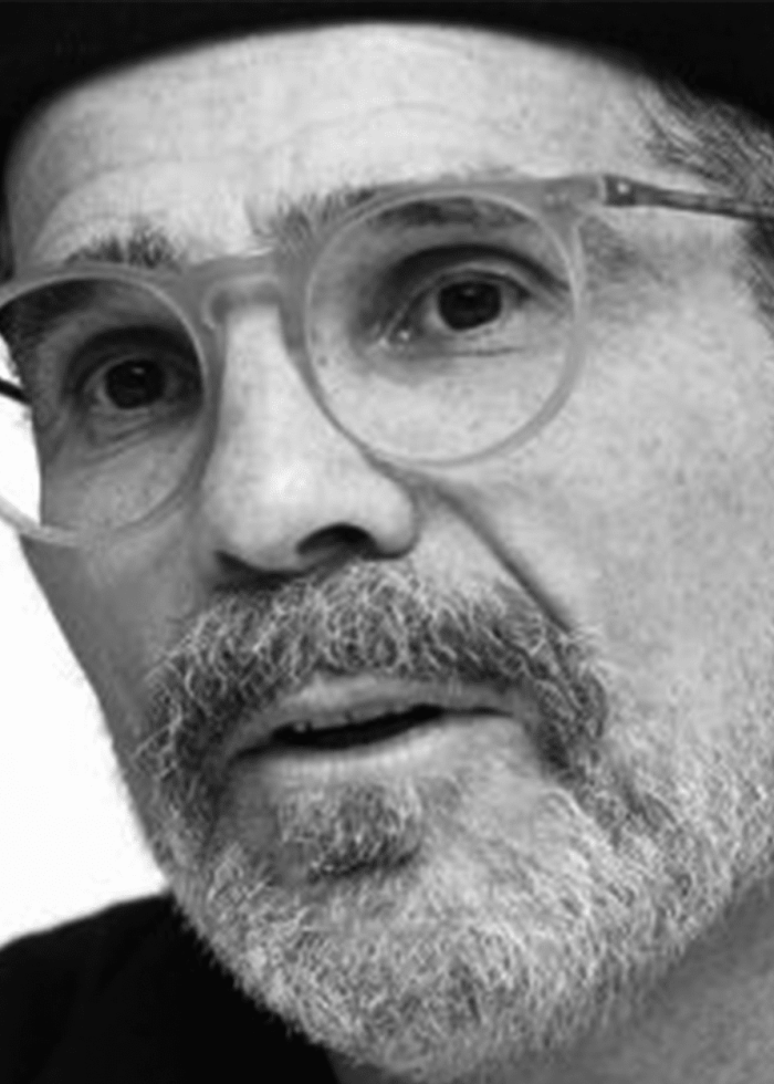 David Mamet, author, wearing glasses and looking intently at the camera.