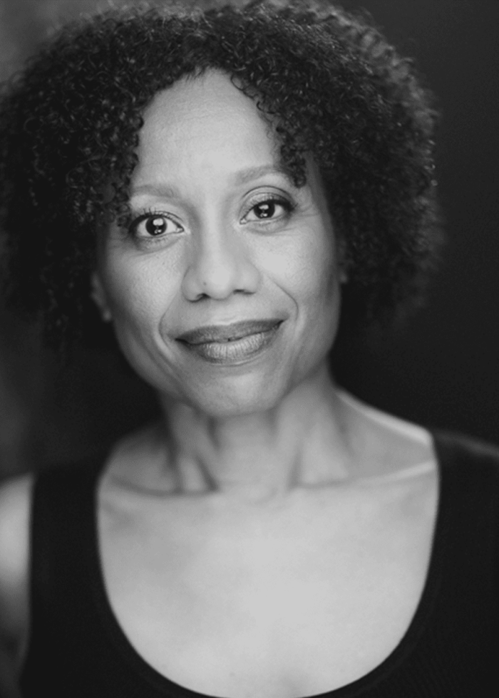 Nehassaiu deGannes, smiling in a black and white portrait