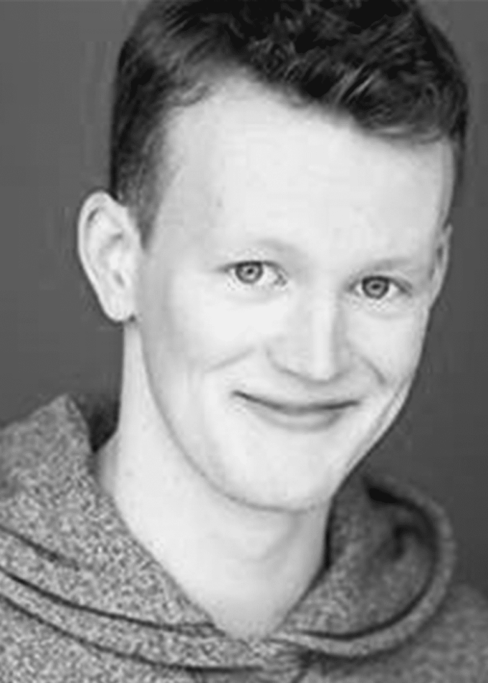 PJ Adzima smiling in a gray hoodie